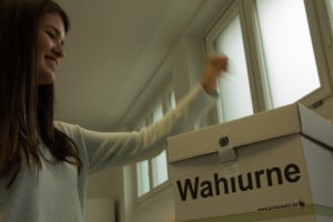 Schülerin wirft ihren Wahlzettel in die Wahlurne